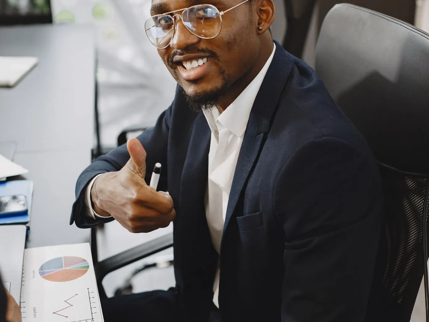 Happy African businessman in a suit giving a thumbs up